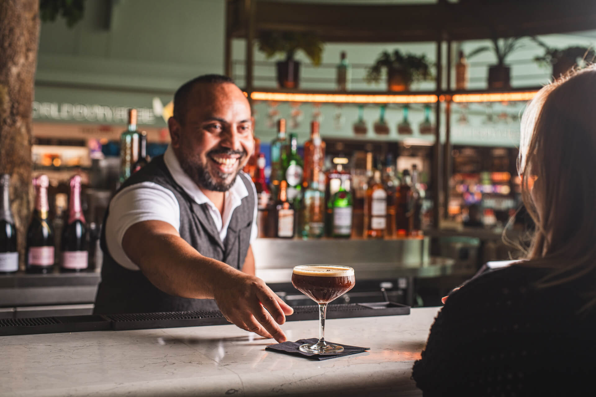 A bartender serving an espresso martini